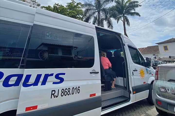 Passenger boarding a shared transfer van from Paraty to hotels in Rio de Janeiro, highlighting convenient travel options.