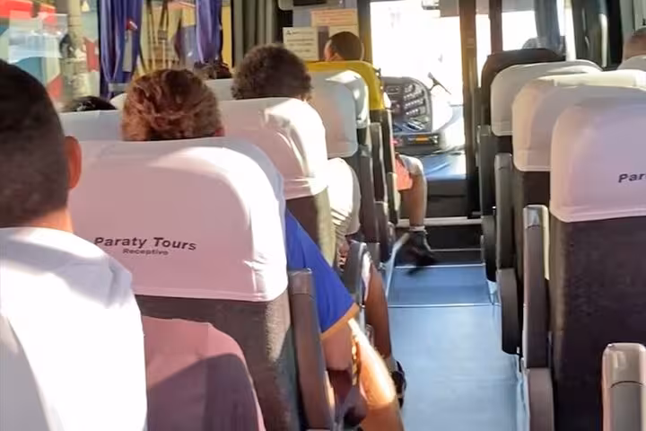 Inside view of a Paraty Tours shuttle bus, passengers comfortably seated en route to Angra dos Reis from Rio de Janeiro.