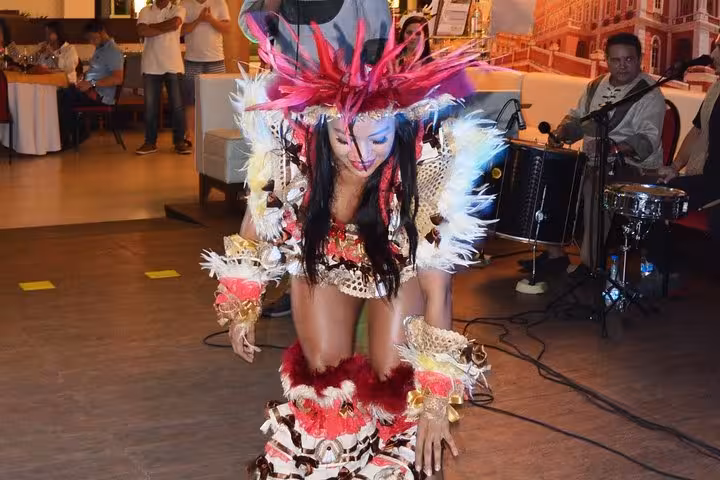 Folklore themed dinner show dancer in vibrant feather costume performing live at Jantar Folclórico Temático