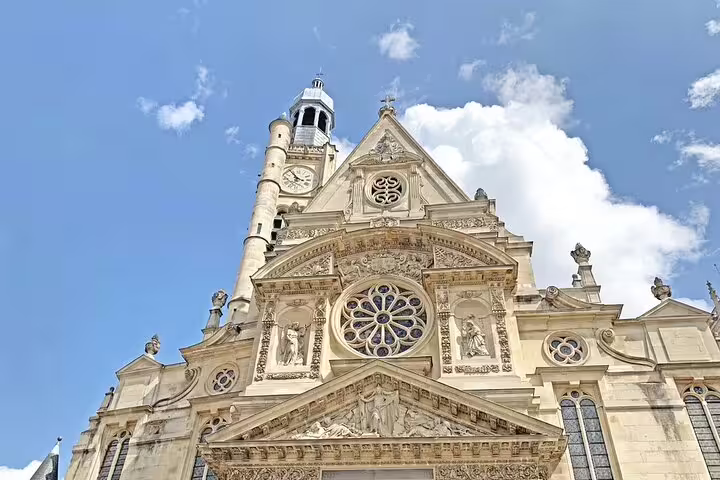 Ornate Gothic facade of Saint-Étienne-du-Mont church in Paris with rose window and clock tower