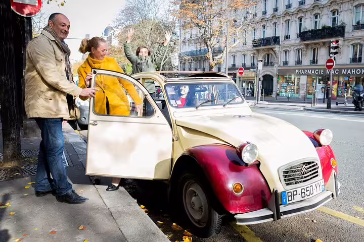 Tourists boarding a vintage Citroën 2CV for a Paris panoramic city highlights tour