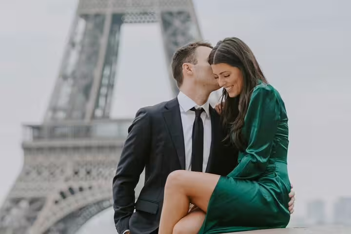 Couple sharing a romantic kiss in front of the Eiffel Tower in Paris