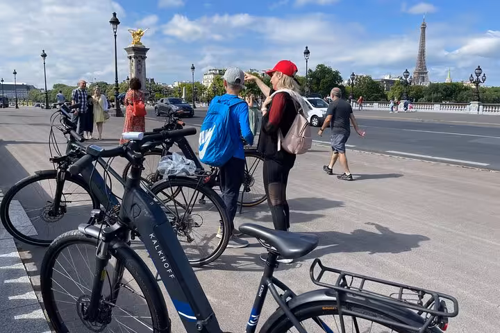 Small group Paris e-bike tour stop on Pont Alexandre III with Eiffel Tower views and guide briefing riders