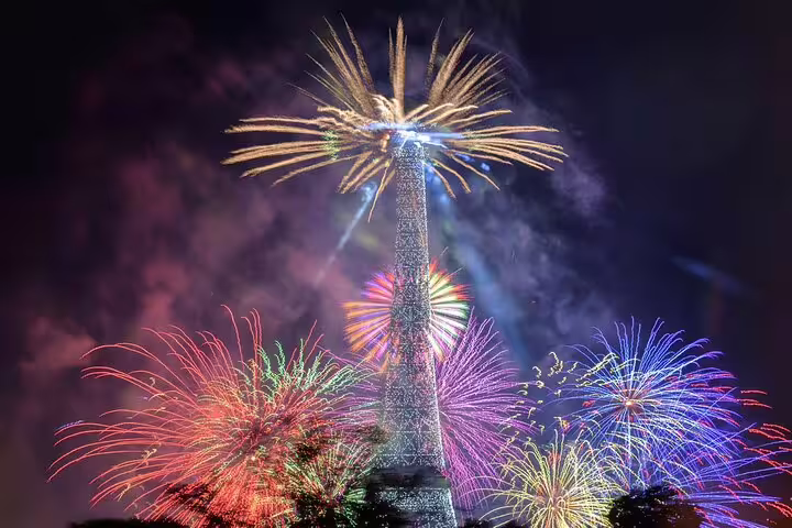 Colorful fireworks exploding around the illuminated Eiffel Tower at night in Paris