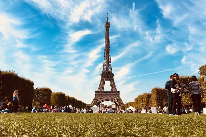 Picnic scene at Champ de Mars with Eiffel Tower, matching a private luxury Eiffel Tower lunch, Seine cruise and Louvre