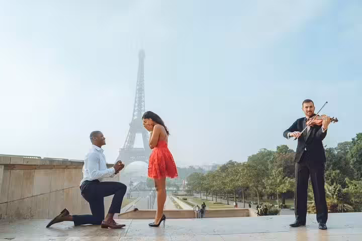 Romantic Eiffel Tower proposal with violinist, Paris engagement photographer capturing surprise moment at Trocadéro