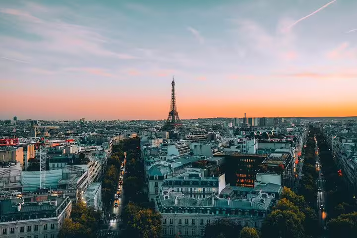 Aerial view of Paris skyline at sunset with Eiffel Tower rising above Haussmann buildings