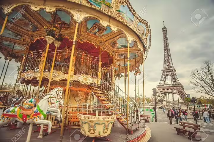 Vintage carousel with colorful horses near the Eiffel Tower in Paris on a cloudy day