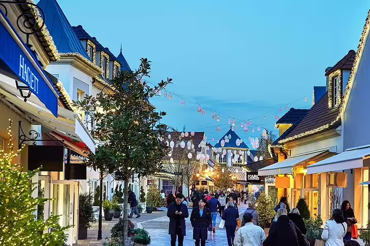 Charming illuminated shopping street in Paris at dusk with string lights and festive decorations