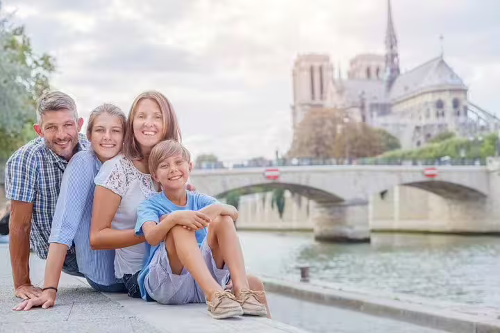 Happy family enjoying a private tour in Paris with Notre-Dame in the background, perfect for kids and city highlights exploration.