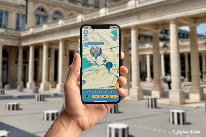 Visitor navigating Paris fashion history tour app at Palais-Royal courtyard with interactive smartphone map guide