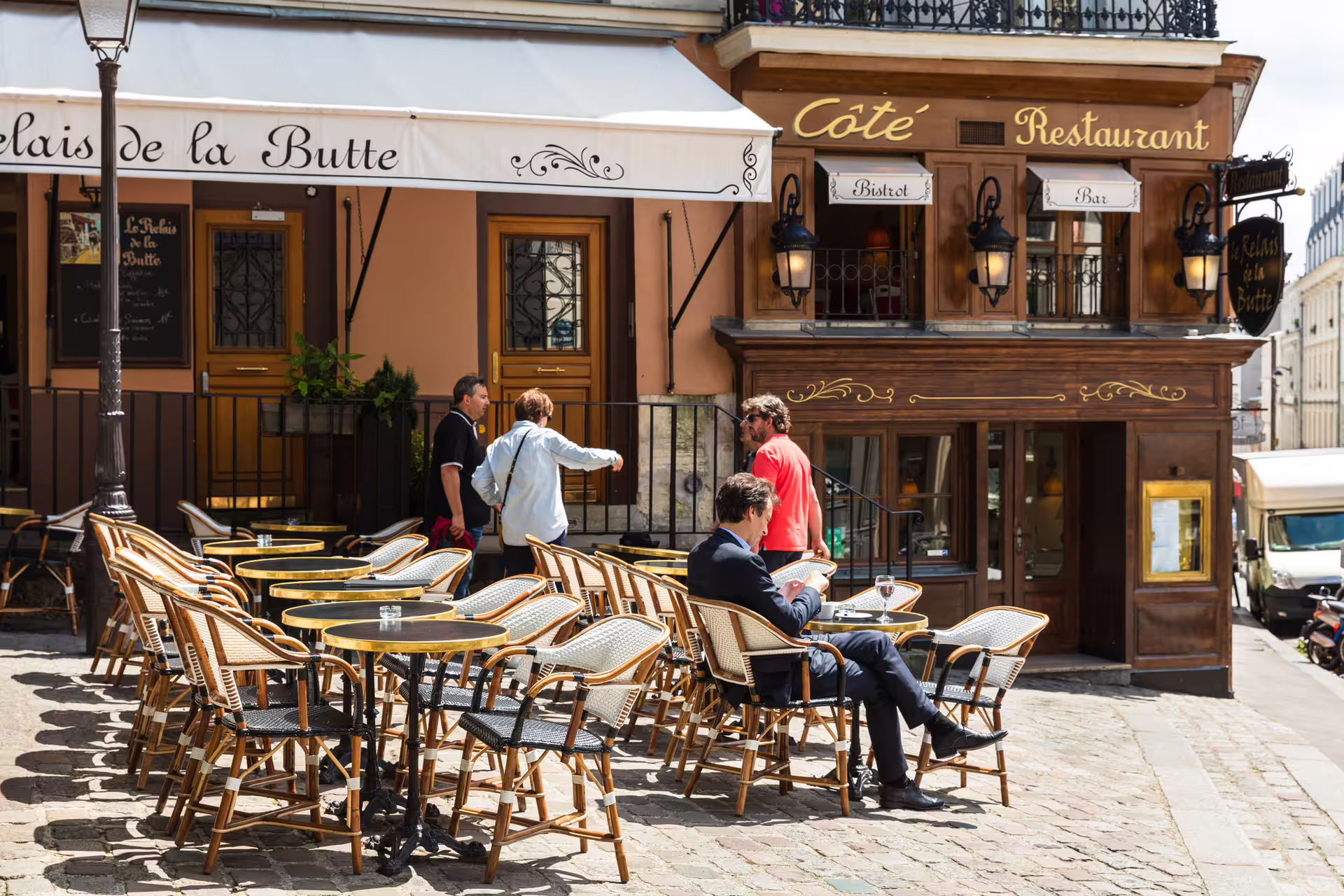 Paris sidewalk café terrace in Montmartre, gourmet stops on 1-day foodie walking tour with audioguide