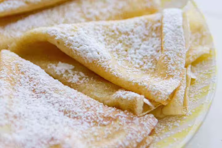 Powdered sugar dusted French crepes folded on a plate in Paris