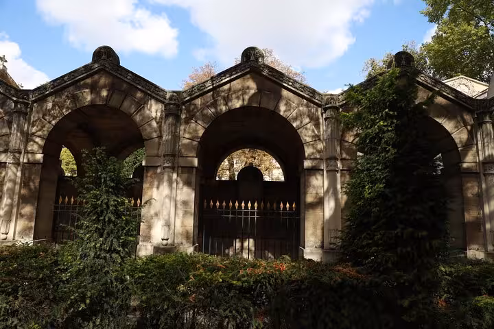 Stone arches and iron gate in a Paris garden, a Second Empire stop on Napoleon III Paris city tour