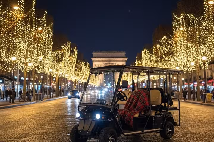 Black golf cart on Champs-Élysées at night with Christmas lights and Arc de Triomphe in Paris