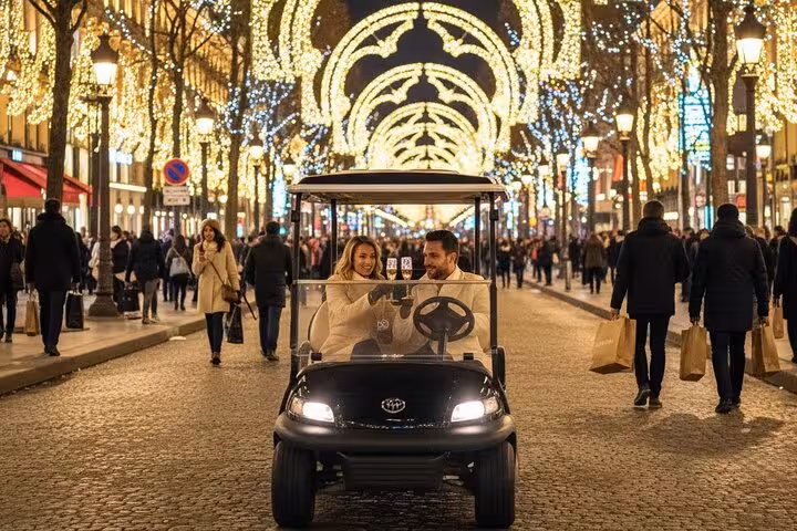 Couple riding a golf cart on the Champs-Élysées under festive Christmas lights in Paris at night