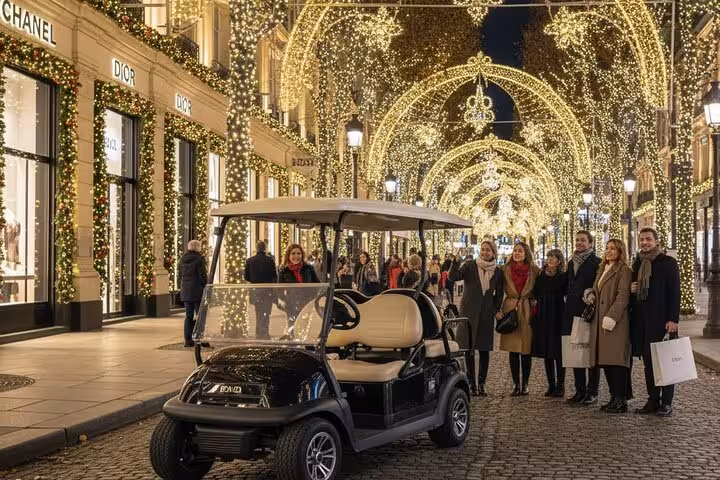 Golf cart tour on a Paris luxury shopping street decorated with golden Christmas lights at night