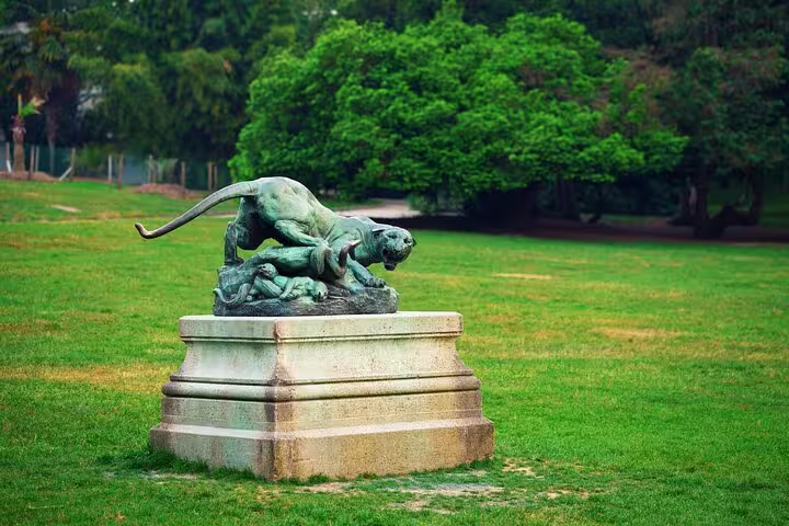 Bronze panther statue on stone pedestal in Paris park green landscape