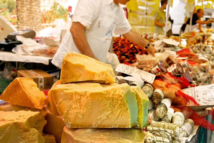 Cheese and charcuterie displayed at a vibrant market stall during the Paris Le Marais Flavors of France Private Walking Food Tour.