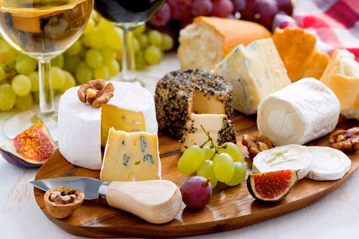 Experience a gourmet cheese platter with wine, figs, and grapes, a highlight of the Le Marais food tour in Paris.