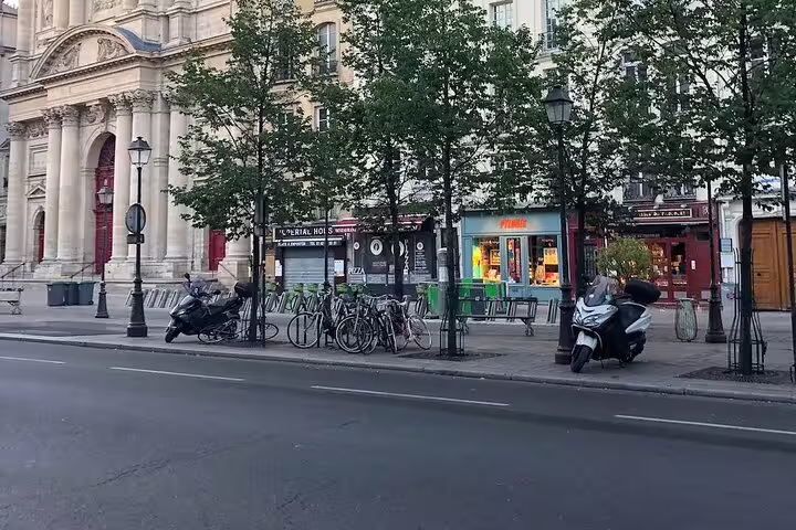 Parisian street with bicycles, scooters, and classic Haussmann architecture in Le Marais district