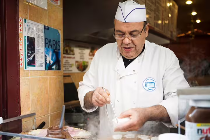 Chef preparing delicious French crepes in a Parisian shop, part of a private tour with skip-the-line Louvre Museum tickets.