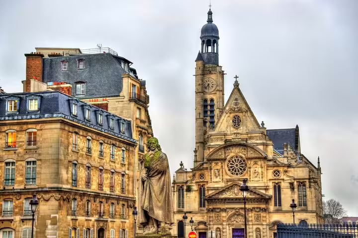 Historic Parisian architecture featuring a statue and the ornate façade of Saint-Étienne-du-Mont Church, ideal for cultural tours.