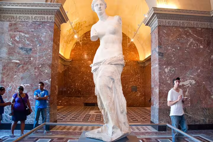 Visitors admire the Venus de Milo statue at the Louvre Museum, featured in a Paris private tour with skip-the-line tickets and French crepes.