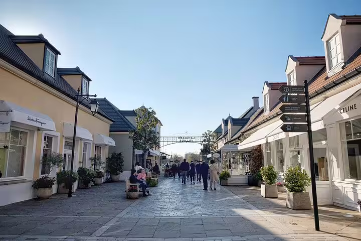 Charming outdoor shopping street with luxury boutiques including Celine and Salvatore Ferragamo on a sunny day