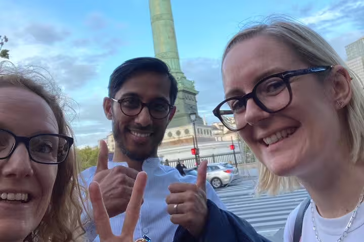 Happy travelers selfie at Place de la Bastille, ideal start for Paris Marais scavenger hunt self-guided tour