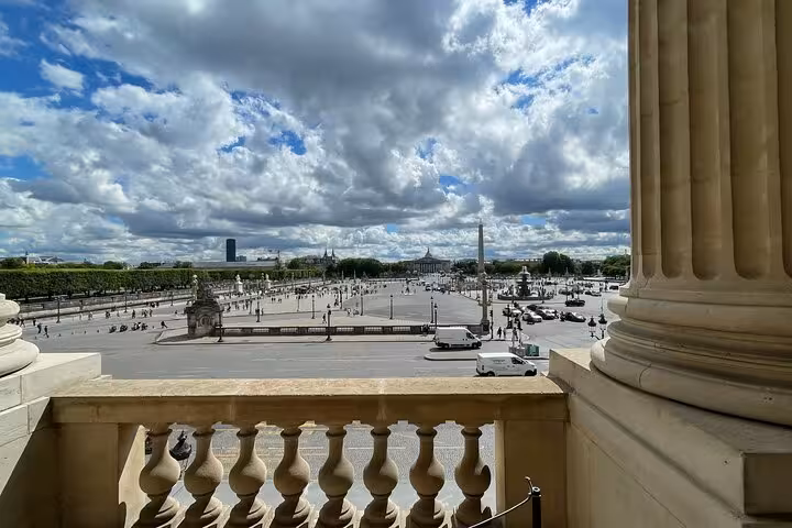 View of Place de la Concorde and obelisk from a classical stone balcony in Paris