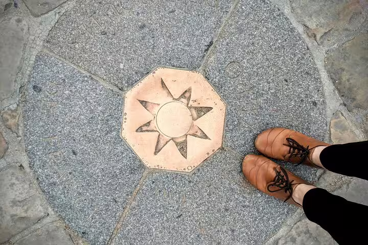 Feet standing next to the Paris Point Zero marker, symbolizing the starting point for a Paris private tour with Louvre access.