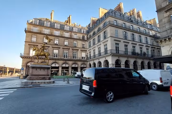 Black Mercedes van private transfer service near Joan of Arc statue in Paris
