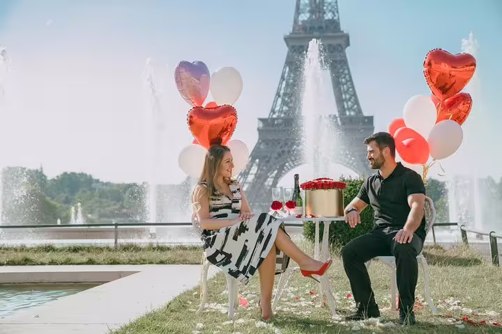 Romantic Eiffel Tower proposal picnic with heart balloons and champagne, captured by Paris proposal photographer