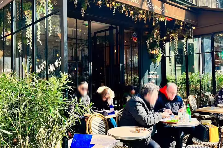 Outdoor café terrace with diners on Saint-Germain street in Paris on a sunny day