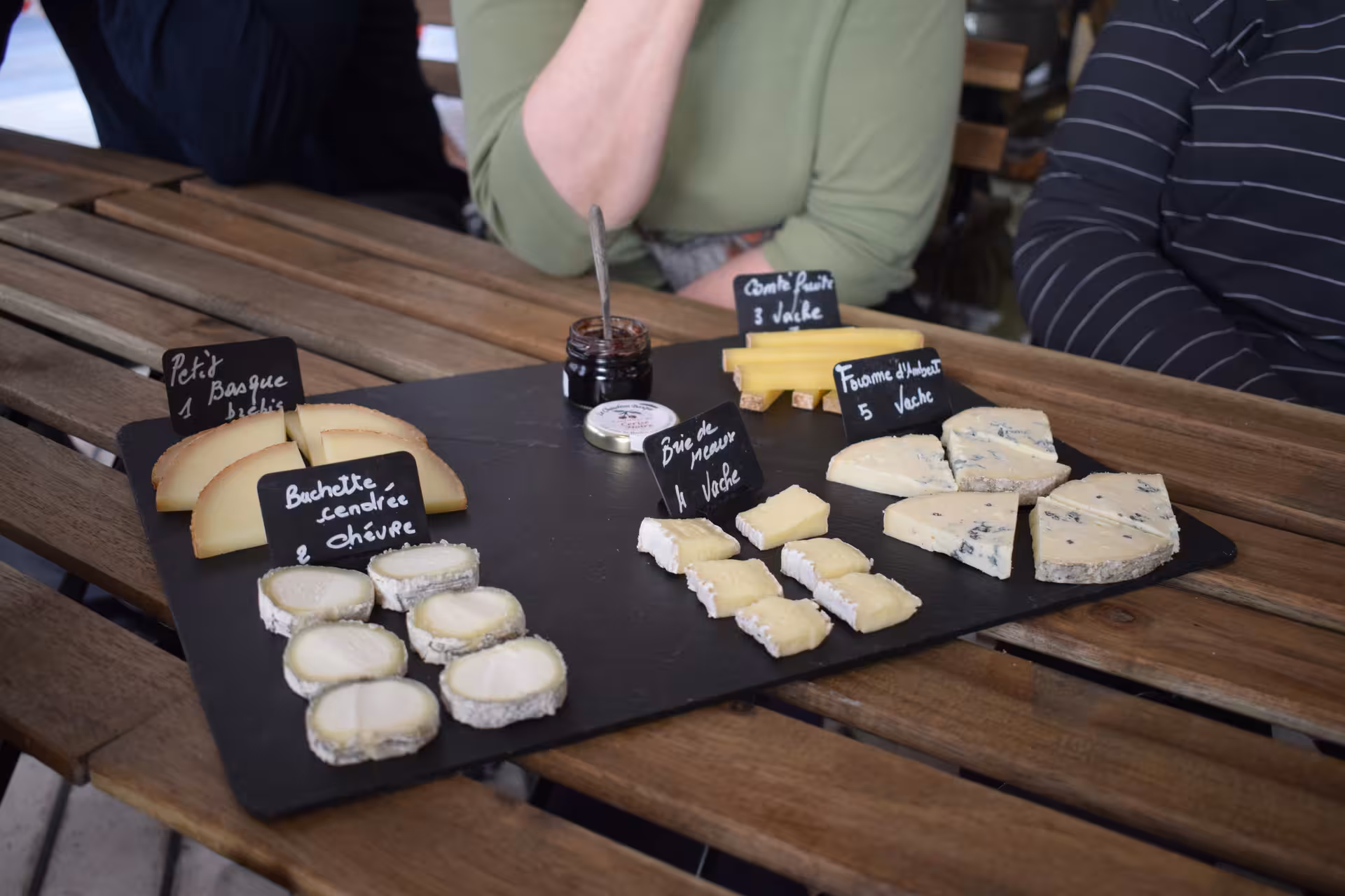 French cheese tasting board with Brie, Comté, Fourme d'Ambert and chèvre on slate platter in Paris
