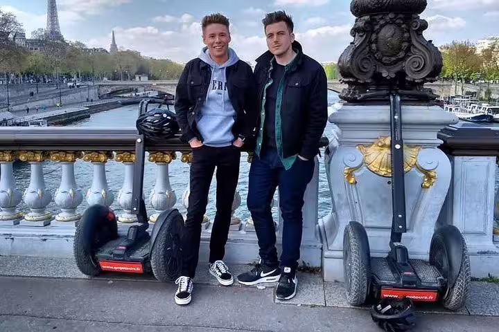Guests on a Paris Segway tour on a Seine bridge with Eiffel Tower view, plus Seine River cruise included