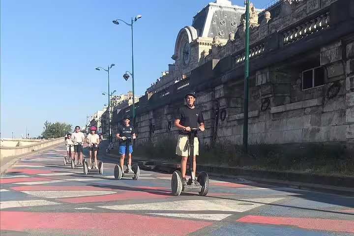 Guided Paris Segway tour group riding along the Seine riverbank, perfect before a Seine River cruise