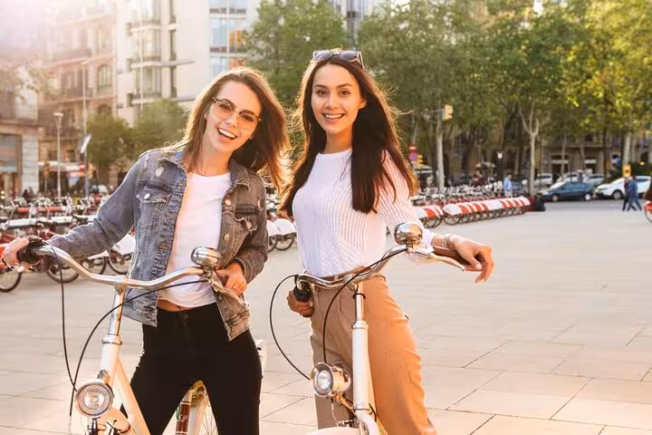 Friends posing with bikes in Paris before a Seine River bicycle tour, with optional Louvre entrance ticket