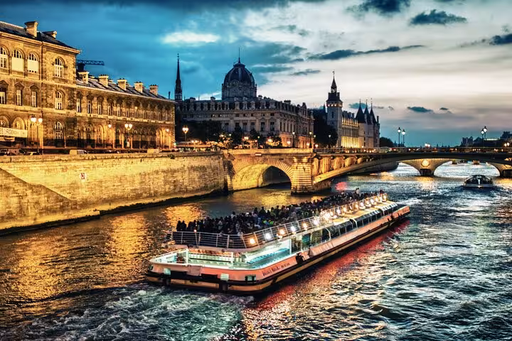 Evening Seine River cruise boat in Paris, part of private tour with luxury Eiffel Tower lunch and Louvre visit