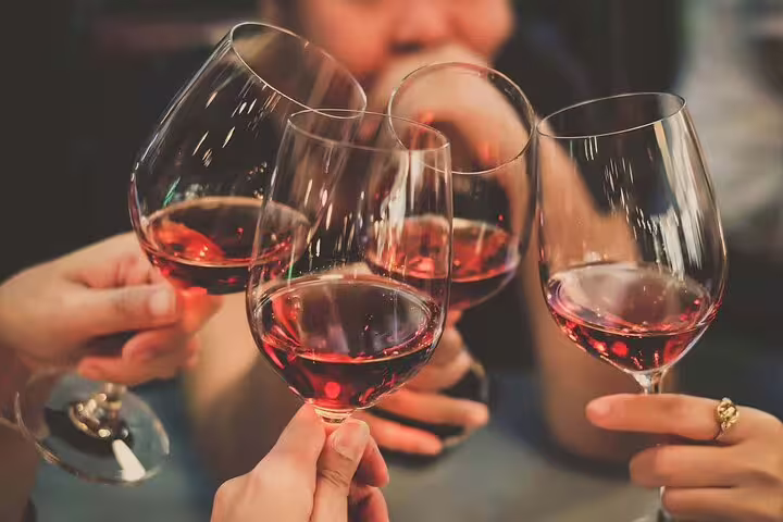 Group of friends toasting with red wine glasses at a Paris celebration
