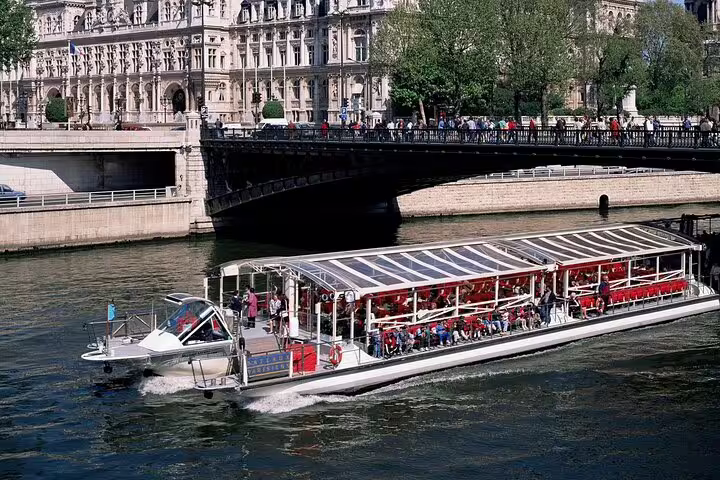 Bateau Mouche river cruise boat on the Seine River passing under a bridge in Paris