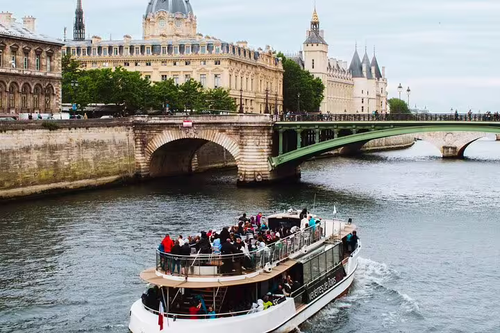 Tourist river cruise boat on the Seine River with the Conciergerie and historic Paris buildings in the background