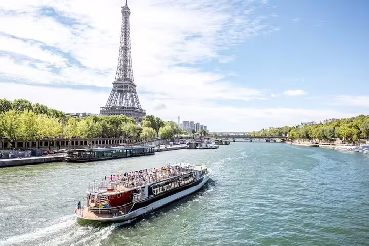 Sightseeing boat cruising the Seine River with Eiffel Tower views on a Paris insider small-group tour and river cruise
