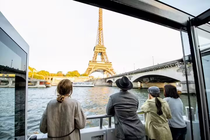 Small group enjoying a Seine River cruise with close-up Eiffel Tower views on a Paris insider guided tour at sunset