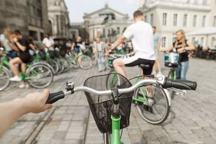 First-person view of green bike in Paris group ride, ideal for Seine River cycling tour near the Louvre