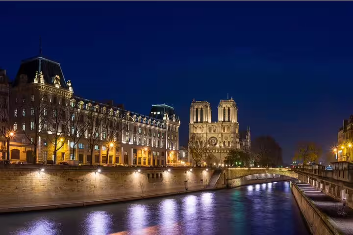Notre-Dame Cathedral and Seine River illuminated at night in Paris