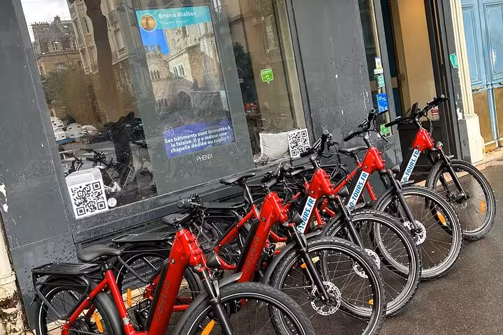 Red electric bikes lined up for a Paris small group highlights e-bike guided tour, ready for riders
