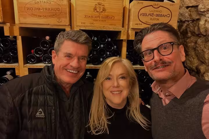 Guests pose in a Paris wine cellar during food, wine and cheese tasting tour with Napoleon love story