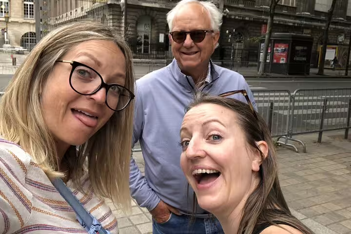 Three tourists smiling for a selfie on a Paris street during a self-guided WWII tour